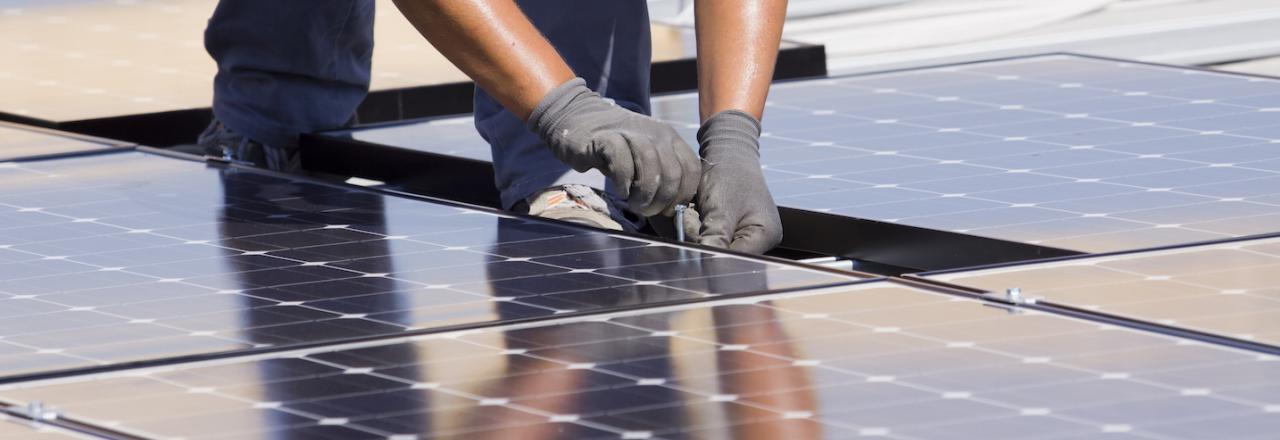 Hands Working on Solar Panel